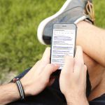 Person am mobilen Telefon im Freien