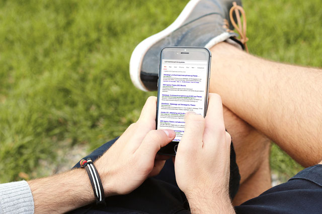 Person am mobilen Telefon im Freien